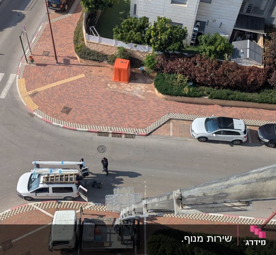 מנוף הרמה סולם בפעולה הפרוס במעלה בניין מגורים